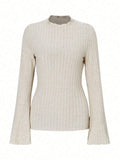 A person wearing a black long sleeve round neck top with a brushed sunken stripe texture and lantern sleeves.