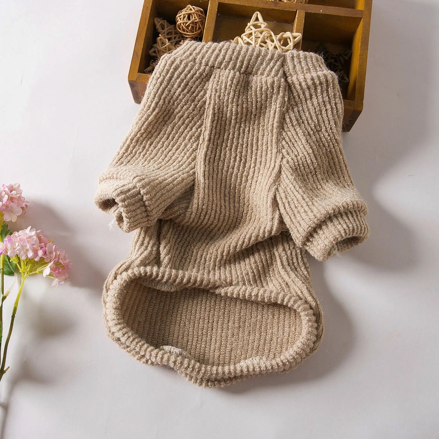 Brown cloth pullover sweater on a small dog, showing casual design.