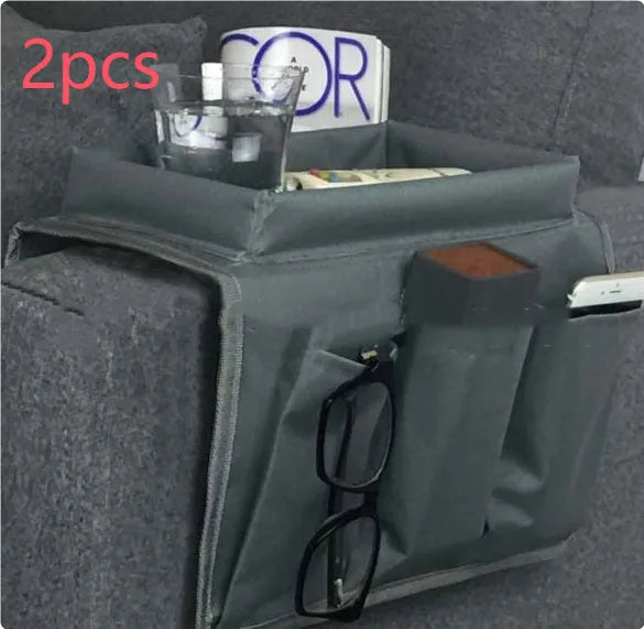 Black Oxford fabric sofa armrest organiser bag with 6 pockets on a couch handrail