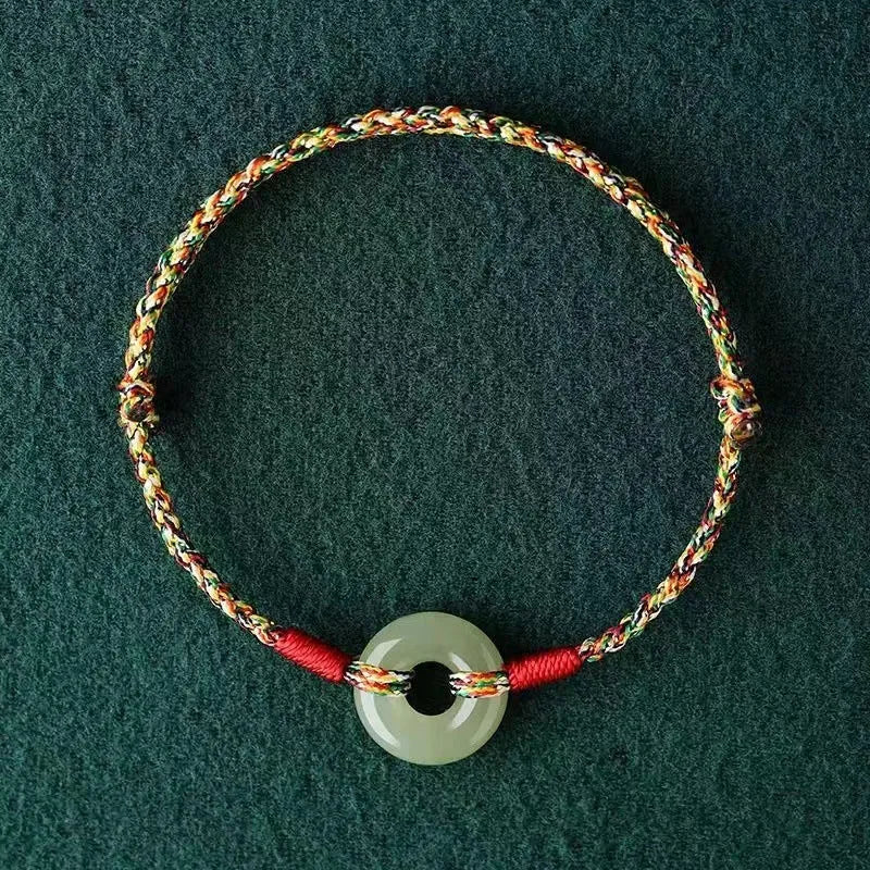 Colourful woven rope bracelet with silver peace buckle closure on wrist