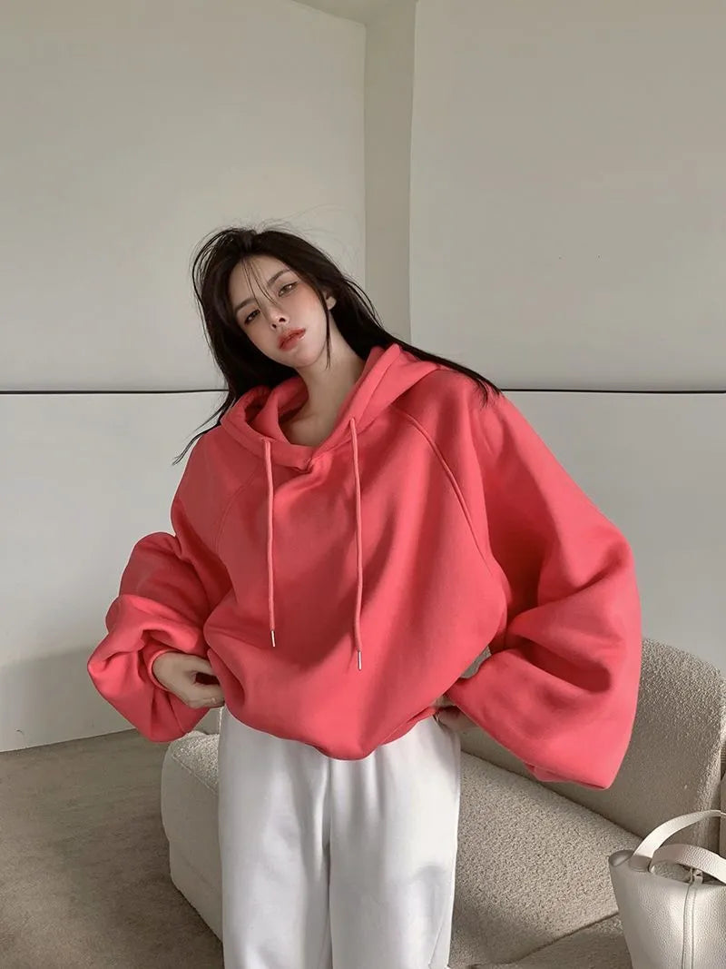 Watermelon red mulberry silk sleeveless hooded sweater for women on a hanger.