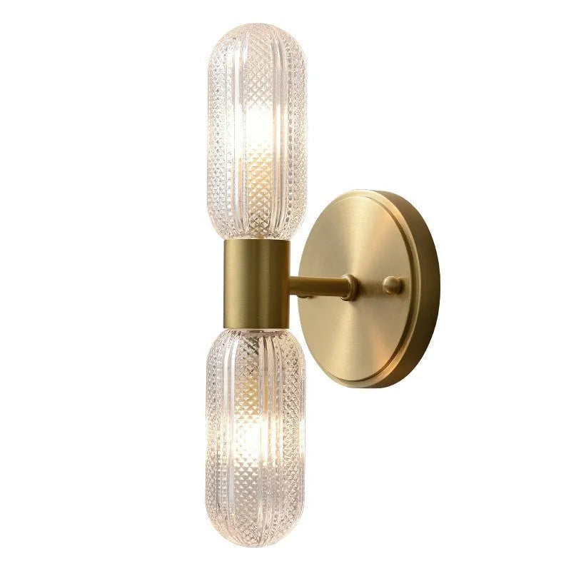 Modern double head wall lamp with a copper finish mounted on a light grey wall.