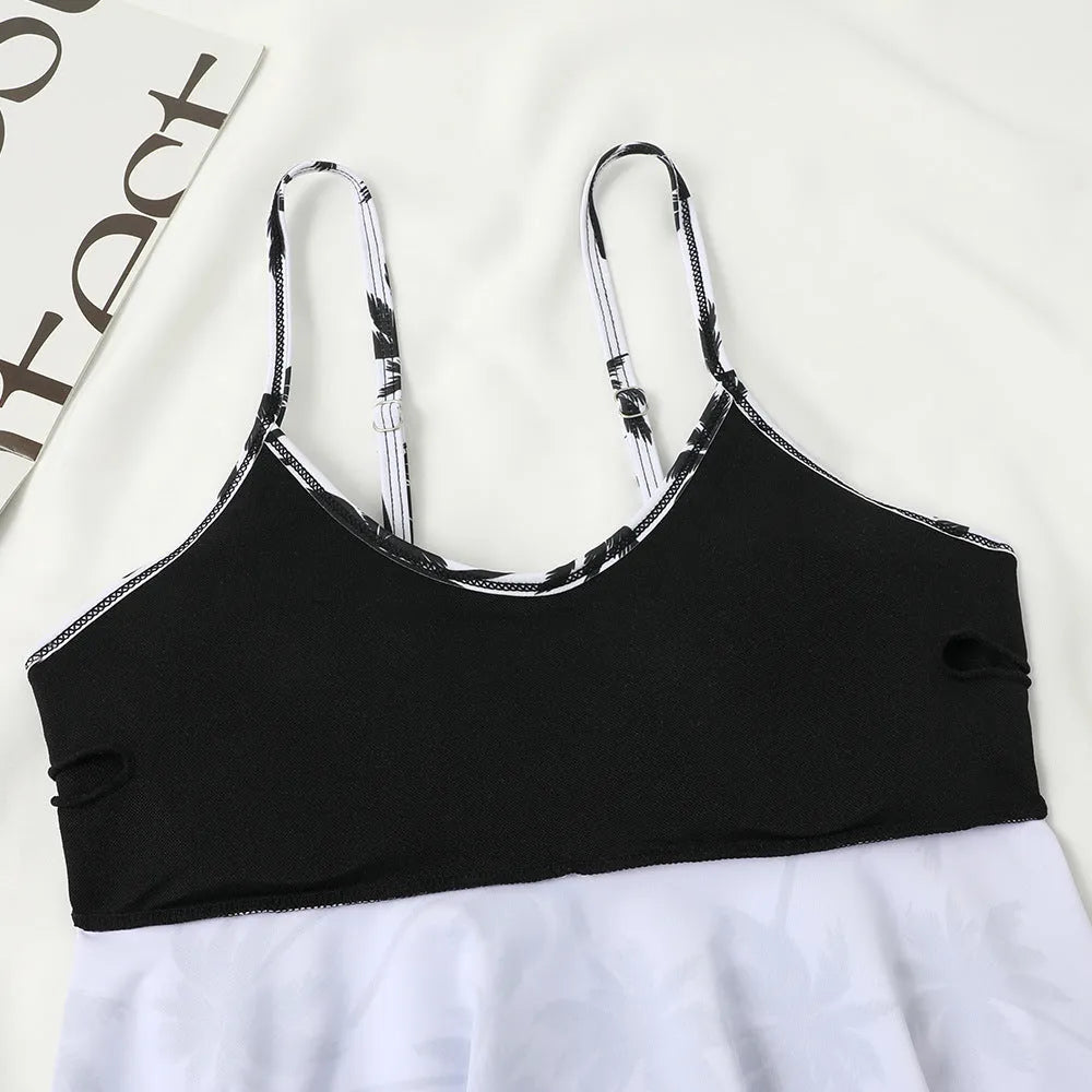 Black high-waisted two-piece swimsuit with a coconut tree print on a model, showing the brief style and double-layer construction.