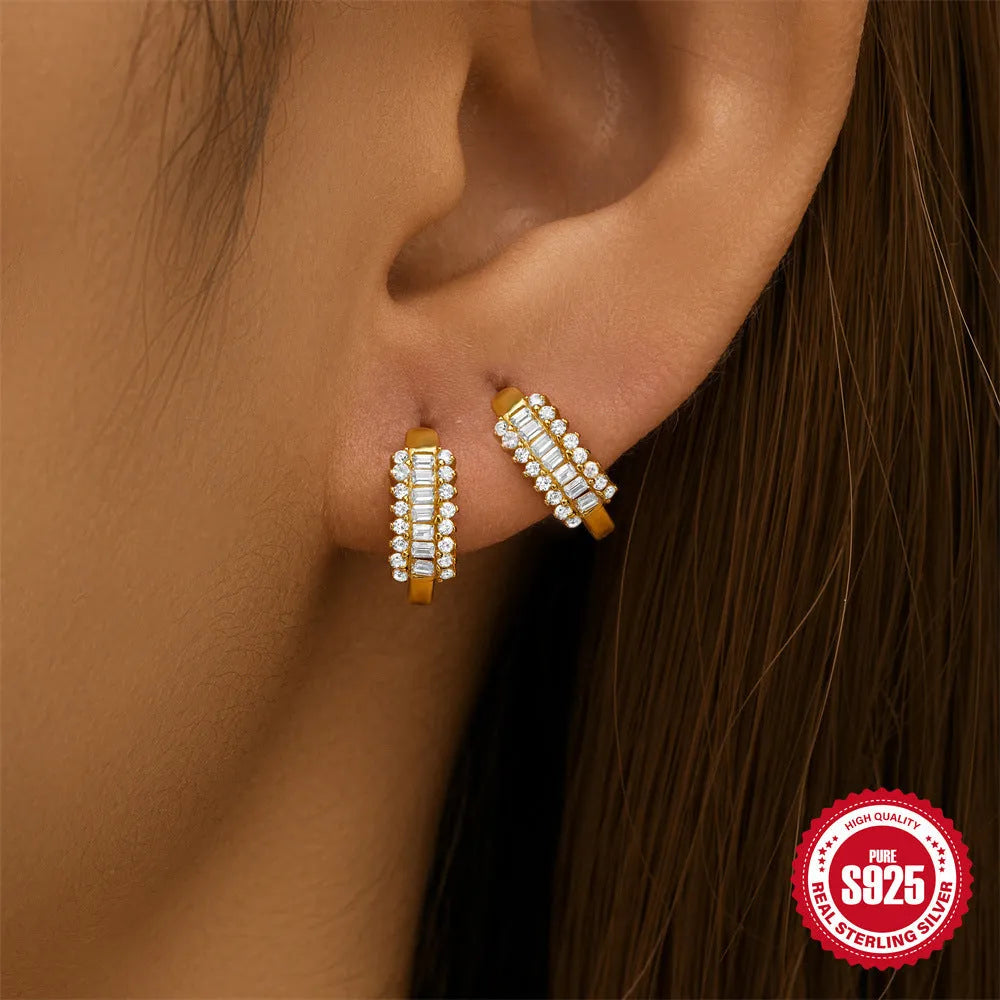 A pair of small round sterling silver geometric stud earrings with a classic diamond detail on a plain background.