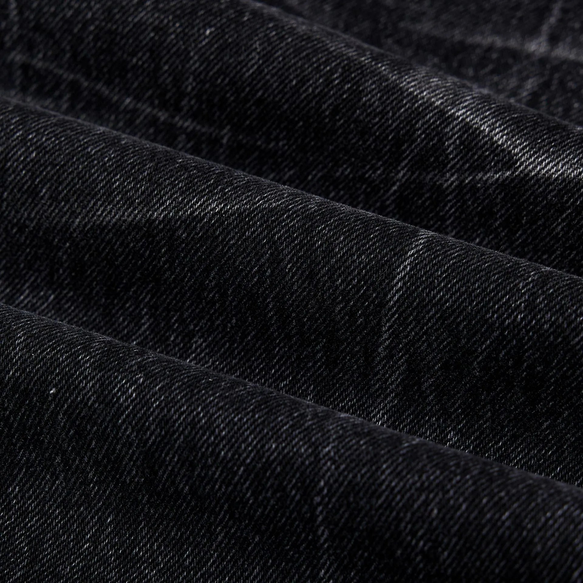 Men's black straight-leg jeans with a distressed lightning crack wash pattern on the legs.