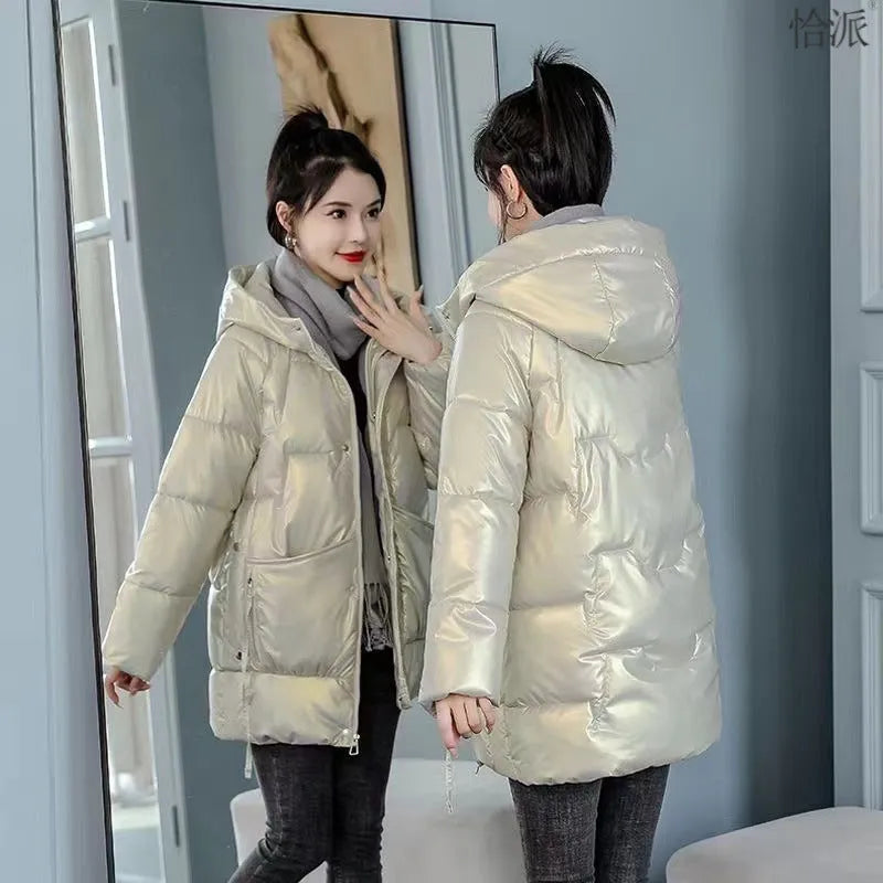 Green loose-fit women's hooded winter jacket with long sleeves on a hanger