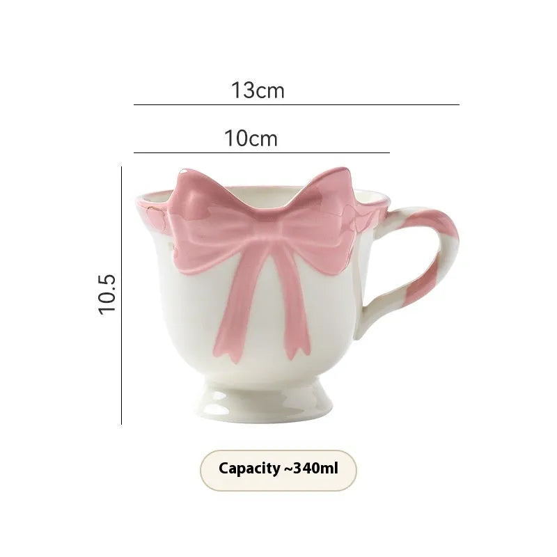 Ceramic mug with heart bow design in white powder and black pink colours.