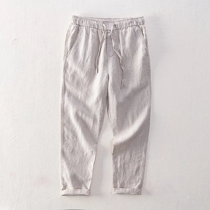 Men's straight leg linen trousers in light grey on a hanger.