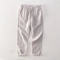 Men's straight leg linen trousers in light grey on a hanger.