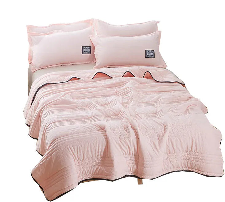 Lightweight seersucker summer quilt in various colours on a bed
