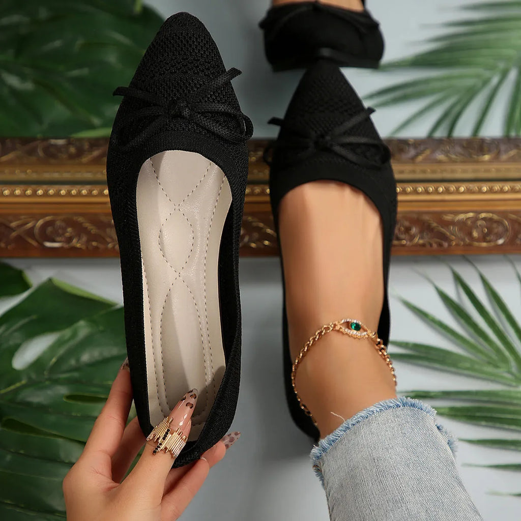 Women's knitted flat loafers with a bow and pointed toe in blue, shown from the side.
