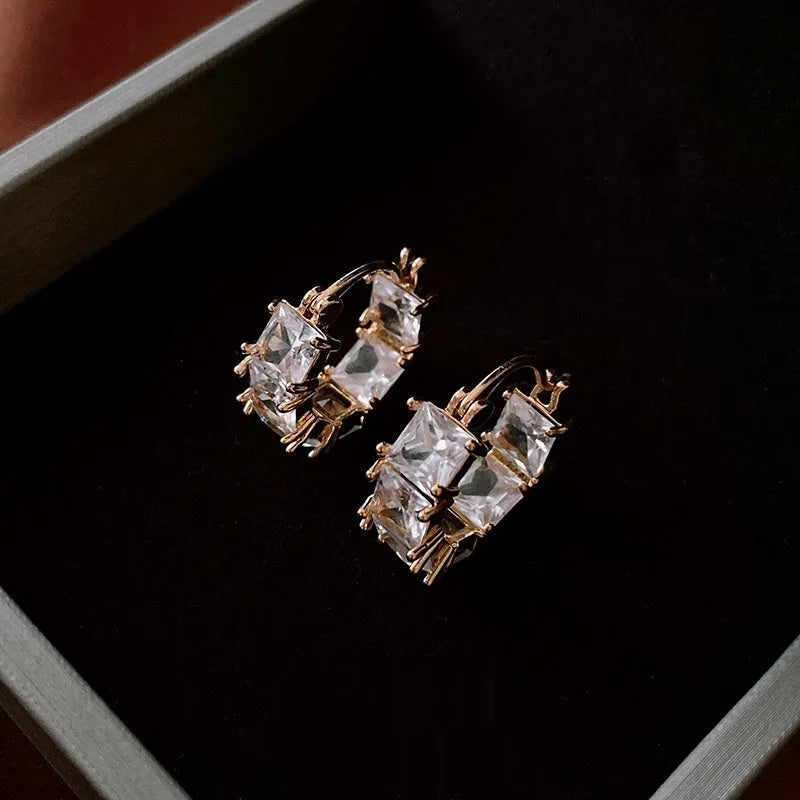 Gold-coloured U-shaped copper earrings with micro-inlaid zircon stones, geometric quadrilateral design, clip-on style.