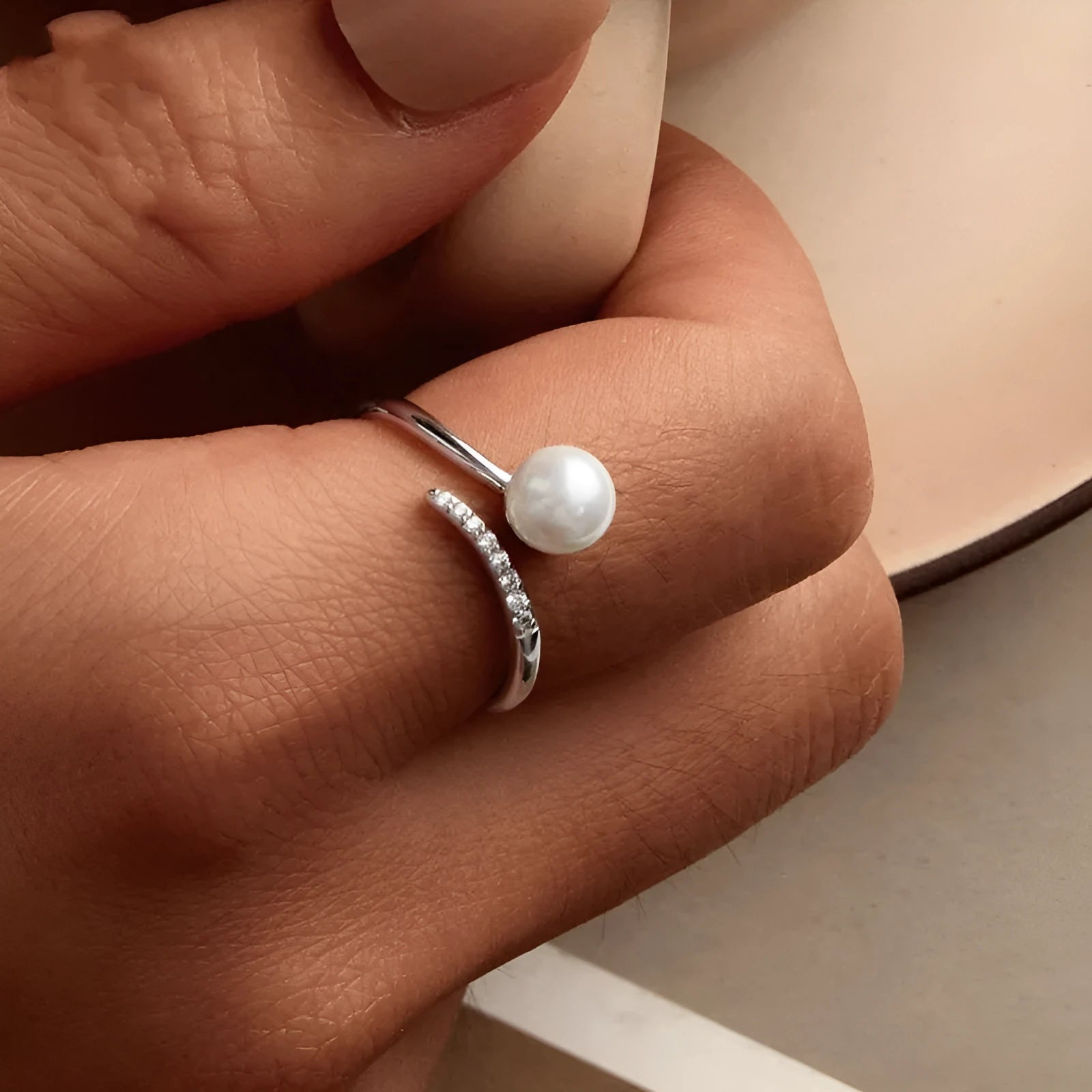 Adjustable open-loop sterling silver ring featuring a genuine shell pearl.