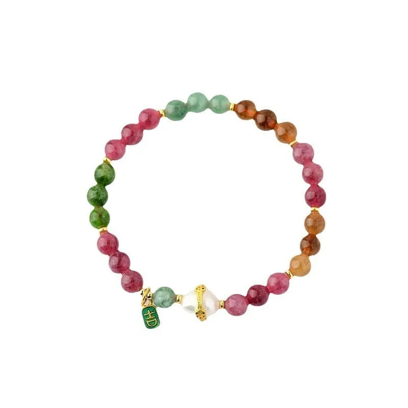 Geometric chalcedony stone bracelet with tourmaline colour beads on a wrist.