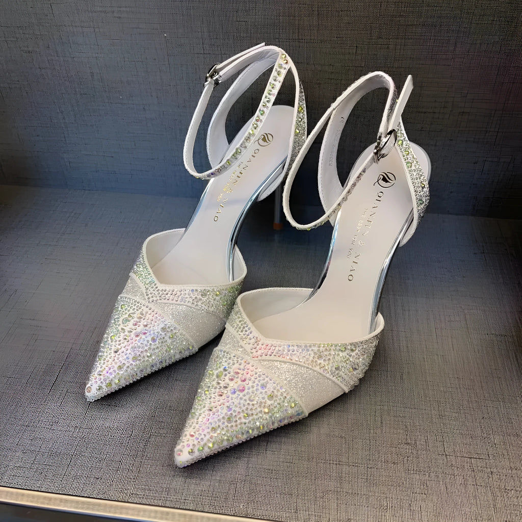 Women's black hollow high heel shoe with red sole, stiletto heel, and pointed toe on a plain background.