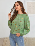 Green women's long-sleeved shirt with butterfly print, showing loose fit and long sleeves.
