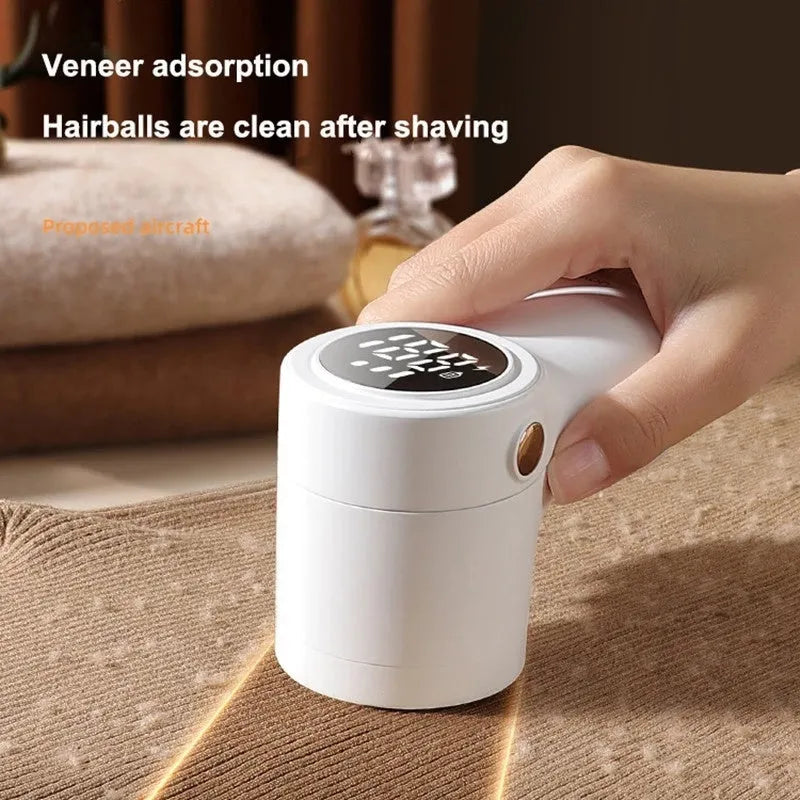 White electric lint remover with LED display and USB charging port on a fabric surface.