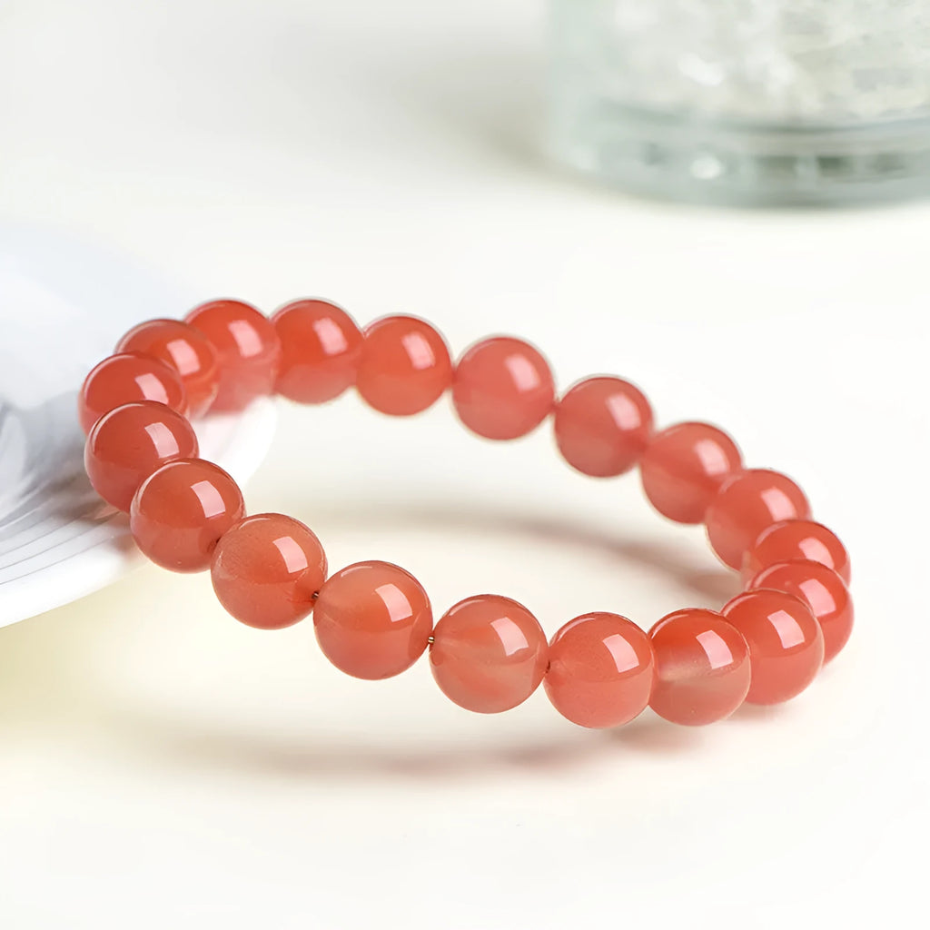 Natural cherry red agate beaded bracelet with high-polish stones on a wrist, showing single and three-strand style options.