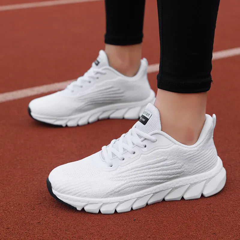Women's black and white low-top running sneakers with cross strap design and MD soles