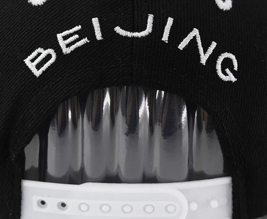 SR Black cotton baseball cap with front letter embroidery, showing adjustable snapback strap and dome crown.