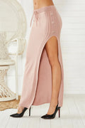 Women's black slim-fit acrylic mid-length skirt with side splits on a mannequin.