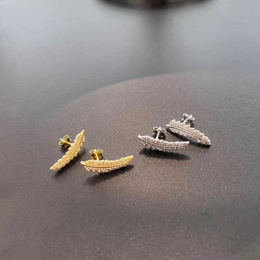 Leaf-shaped zircon inlaid S925 sterling silver stud earrings in gold colour on white background