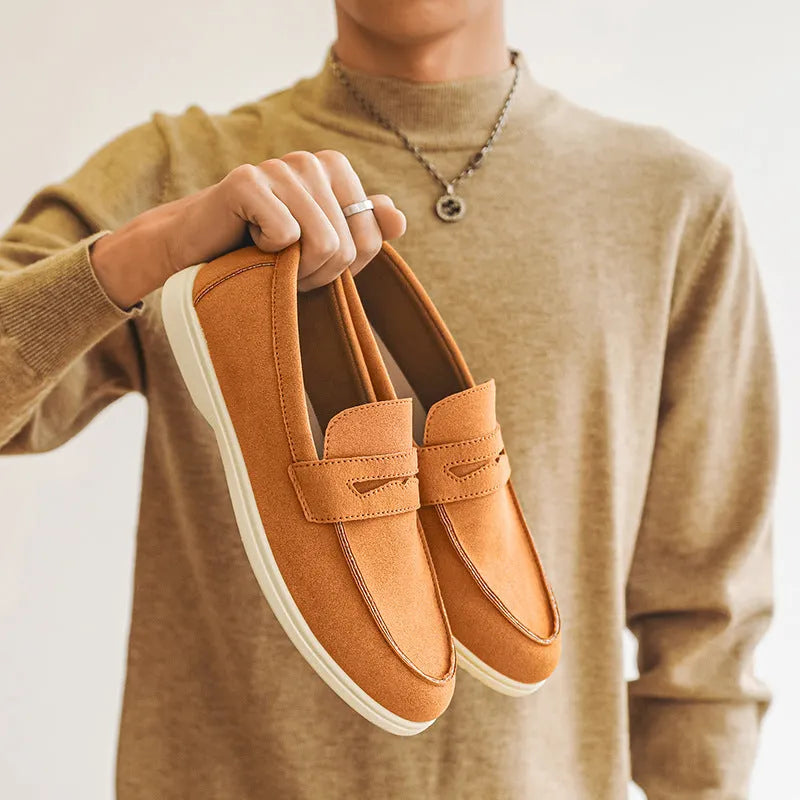 Men's beige suede British style casual slip-on shoes with a round toe and low flat heel on a rubber sole.