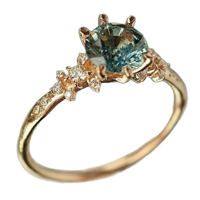 Gold plated geometric claw ring with a set zircon stone and textured square pattern band.