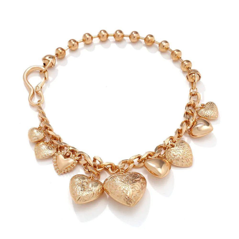 Gold tone carved heart-shaped pendant on an adjustable metal chain necklace.