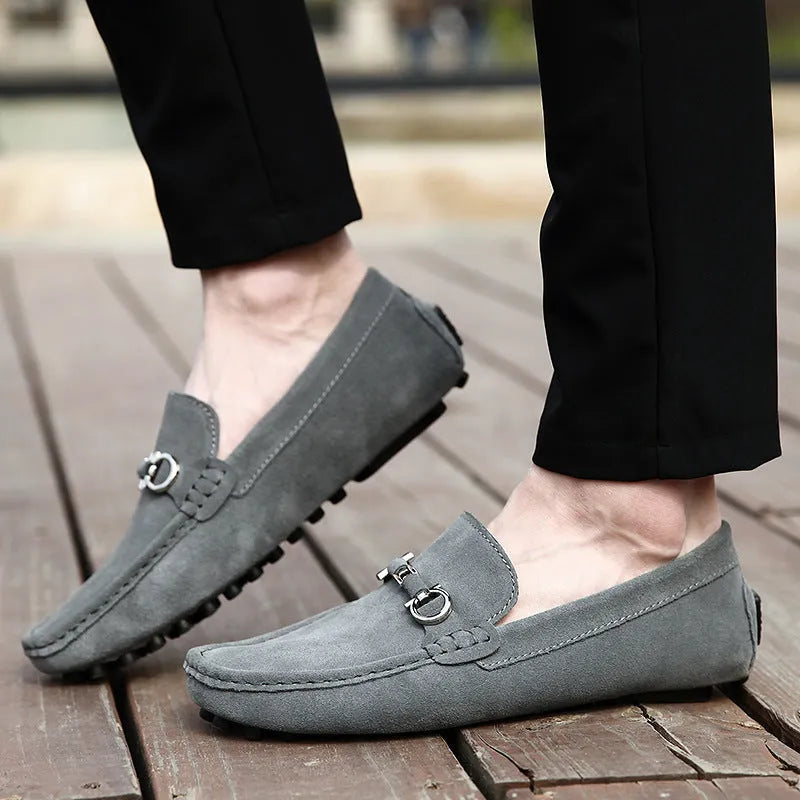 Men's black slip-on leather shoes with square toe and flat rubber sole on a neutral background.