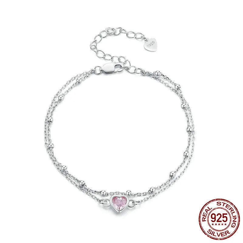 Silver heart-shaped charm bracelet for women on an adjustable chain.