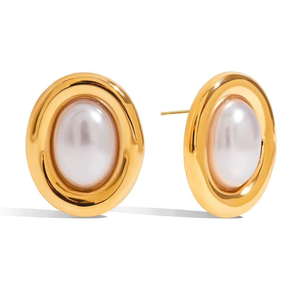 A pair of small stainless steel ear studs with a vintage-style pearl decoration on a silver-coloured base.