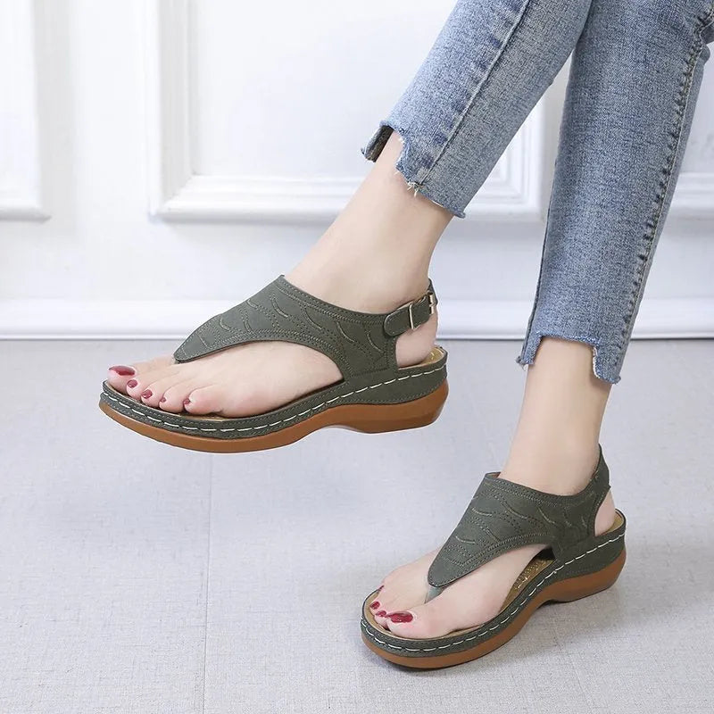 Women's wedge heel flip flop sandals with an adjustable back strap in solid black.