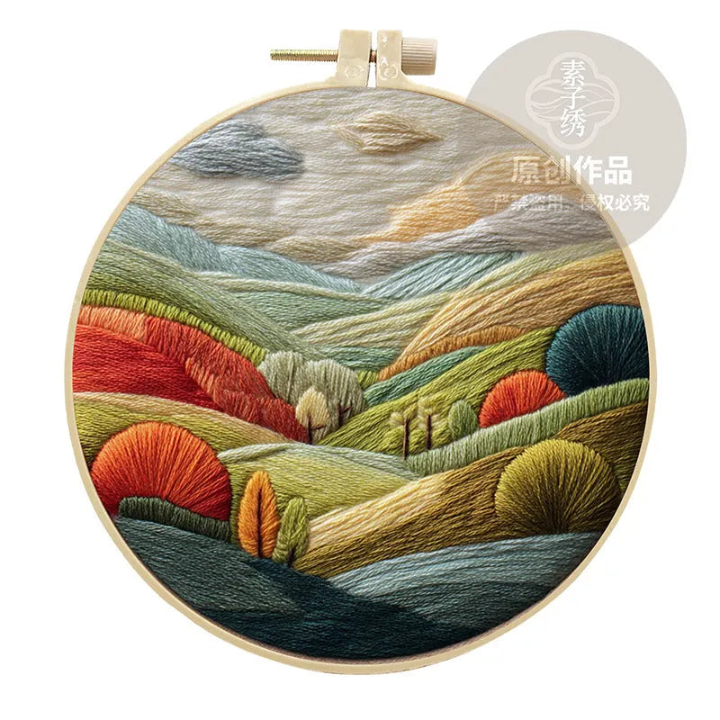 Embroidery DIY kit with landscape designs on cotton fabric, bamboo frame, thread, and needles