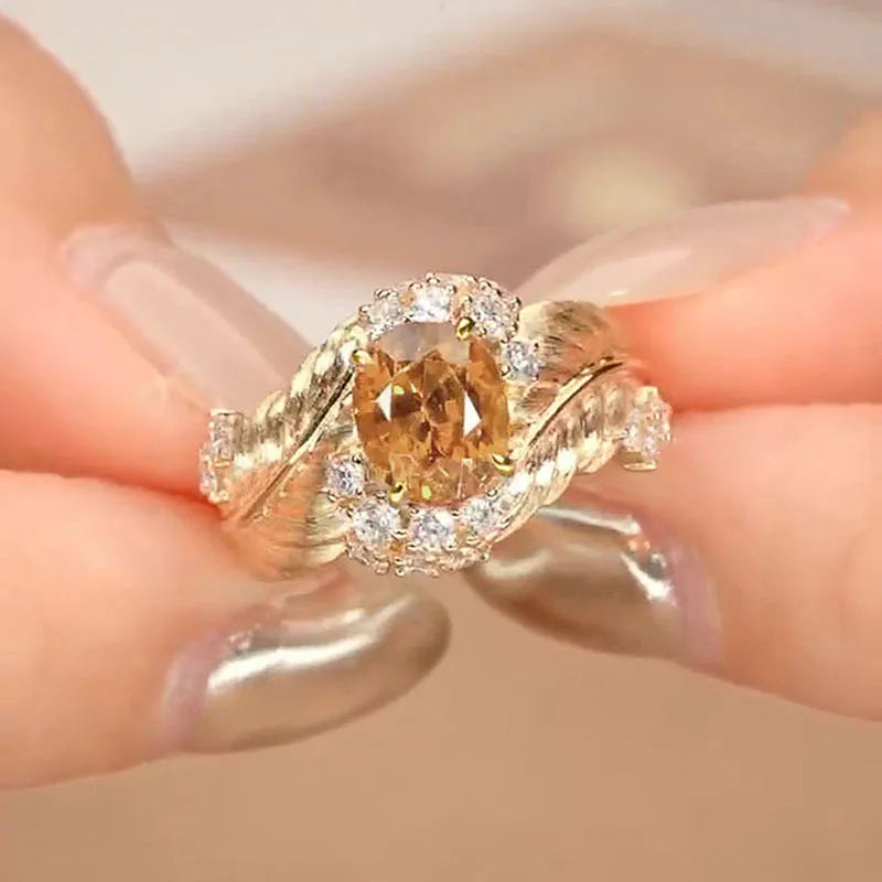 Gold-colour copper feather ring with a geometric design and a yellow zircon stone.