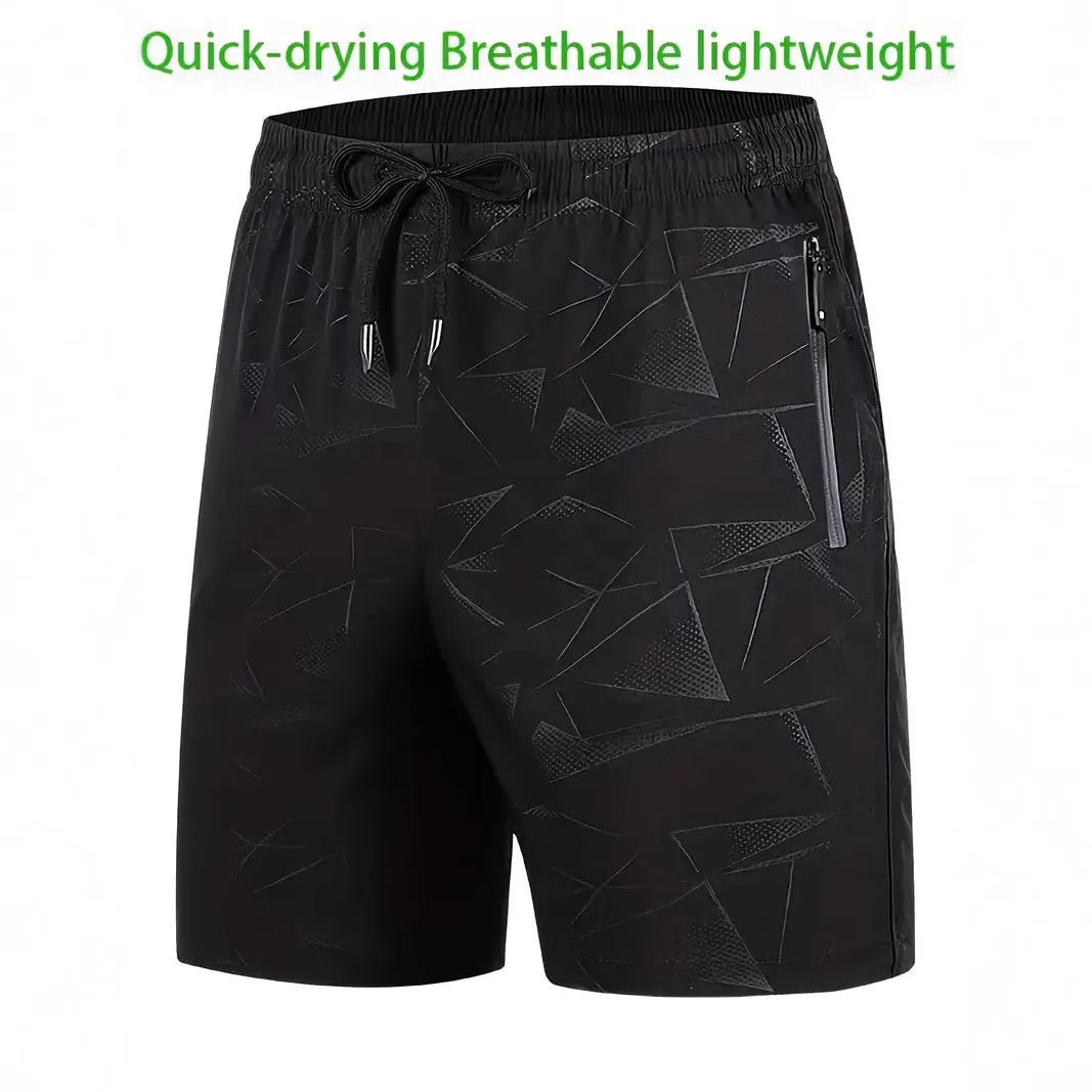 Man wearing loose black printed sports shorts on a beach.