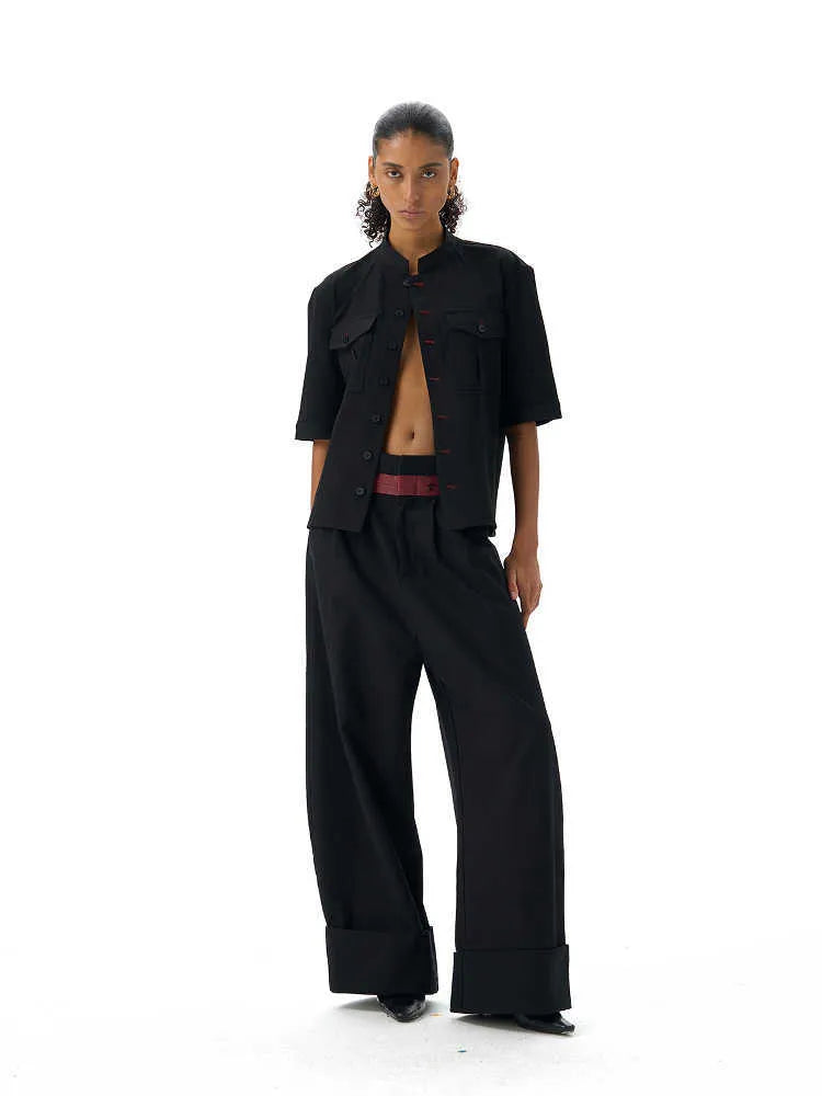 Handmade black loose-fit half sleeve hunting shirt with a shirt collar on a hanger.