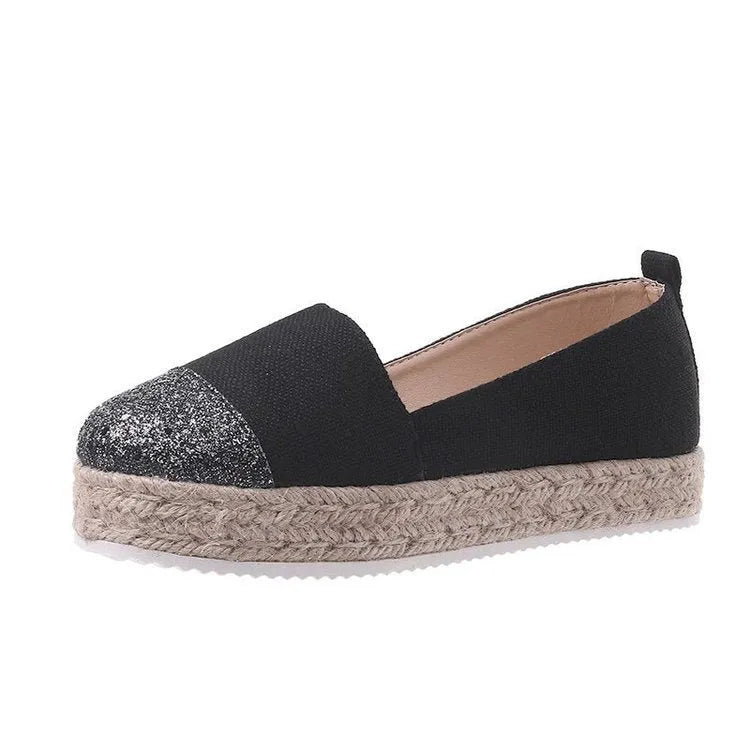Plus size beige canvas slip-on flat shoes with a round toe on a white background.
