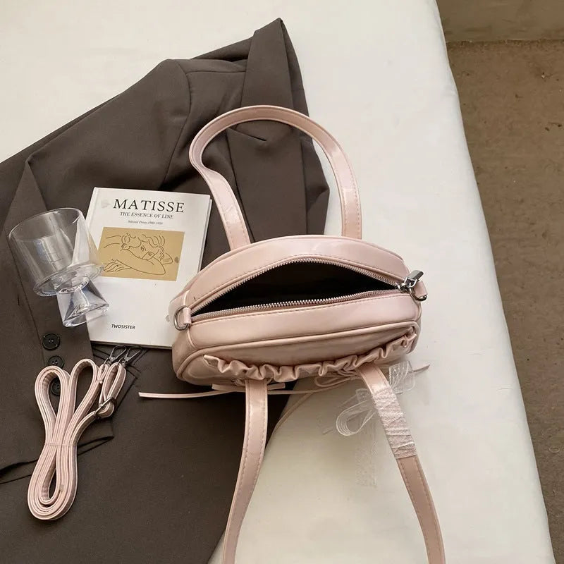 Women's casual PU leather shoulder bag with a bandage bow design and internal phone compartment.