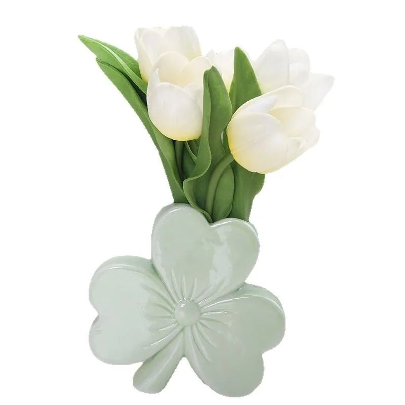 Square white porcelain clover ceramic vase on a desk, shown in light green colour.