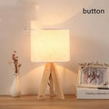 Solid wood LED table lamp with fabric shade in linen trumpet colour on wooden bedside table