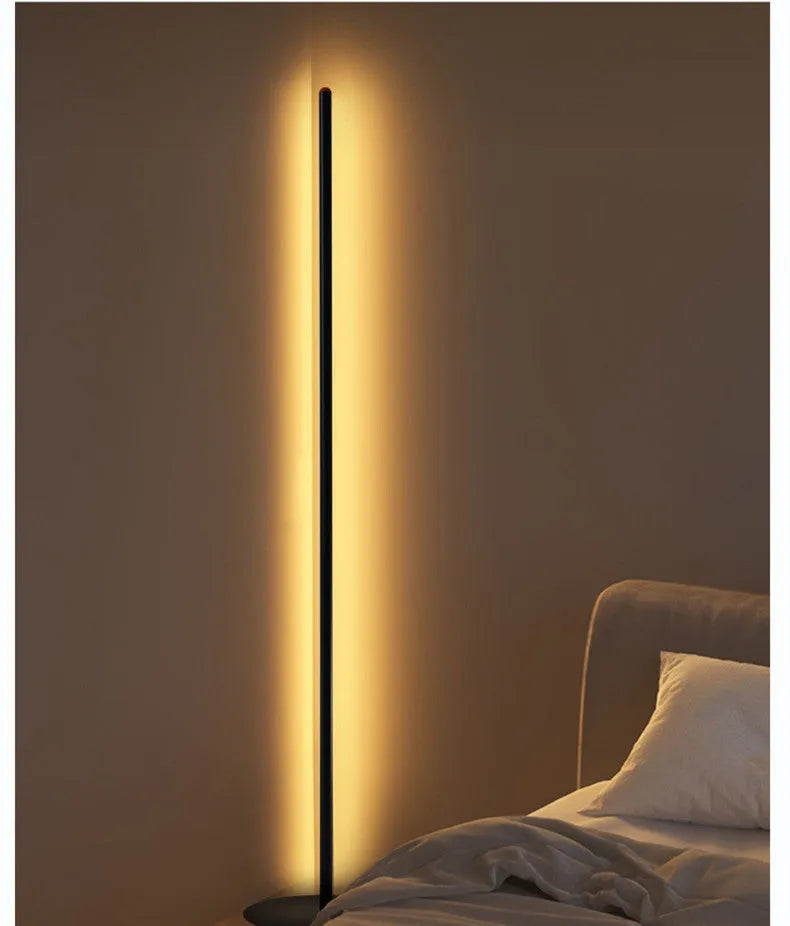 Vertical aluminium alloy floor lamp in modern simple style placed beside a sofa.