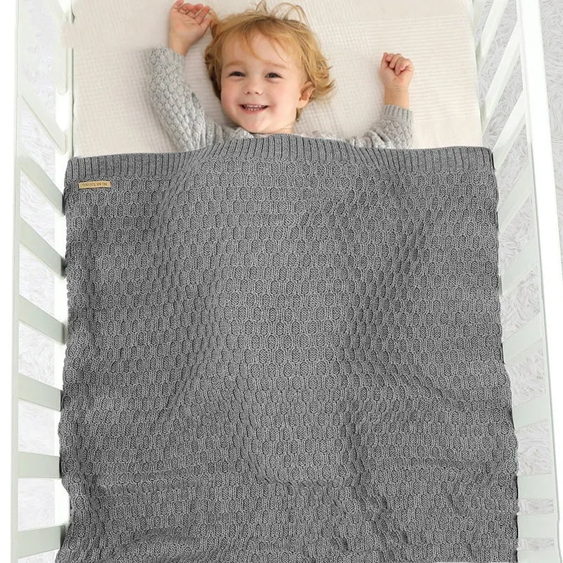 Solid-colour baby blanket with a textured line pattern, shown in a light green colour, folded to display its 70x90cm size.