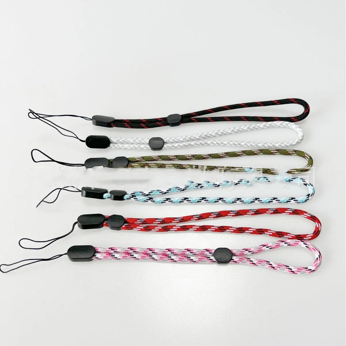 Adjustable round woven mobile phone lanyard in pink, white, and black colours
