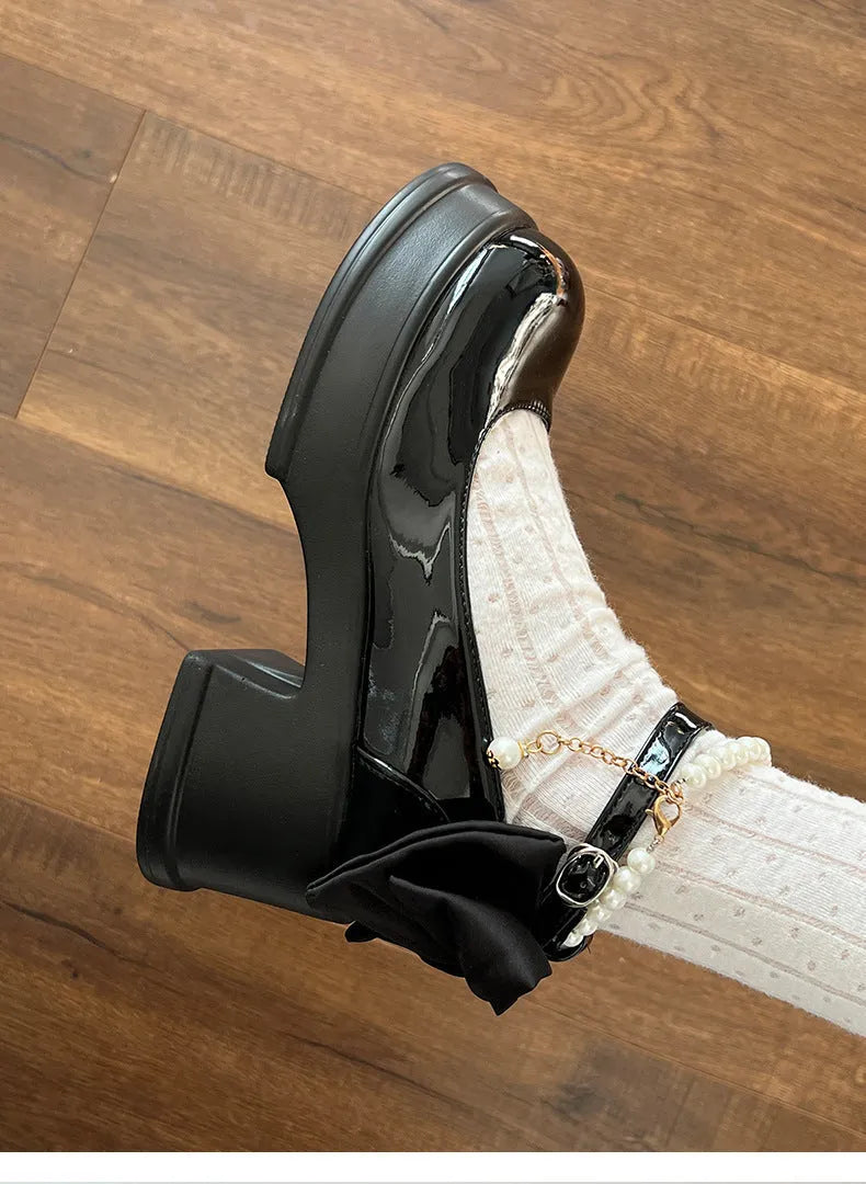 Women's black and beige Mary Jane pumps with a chunky heel and round toe.